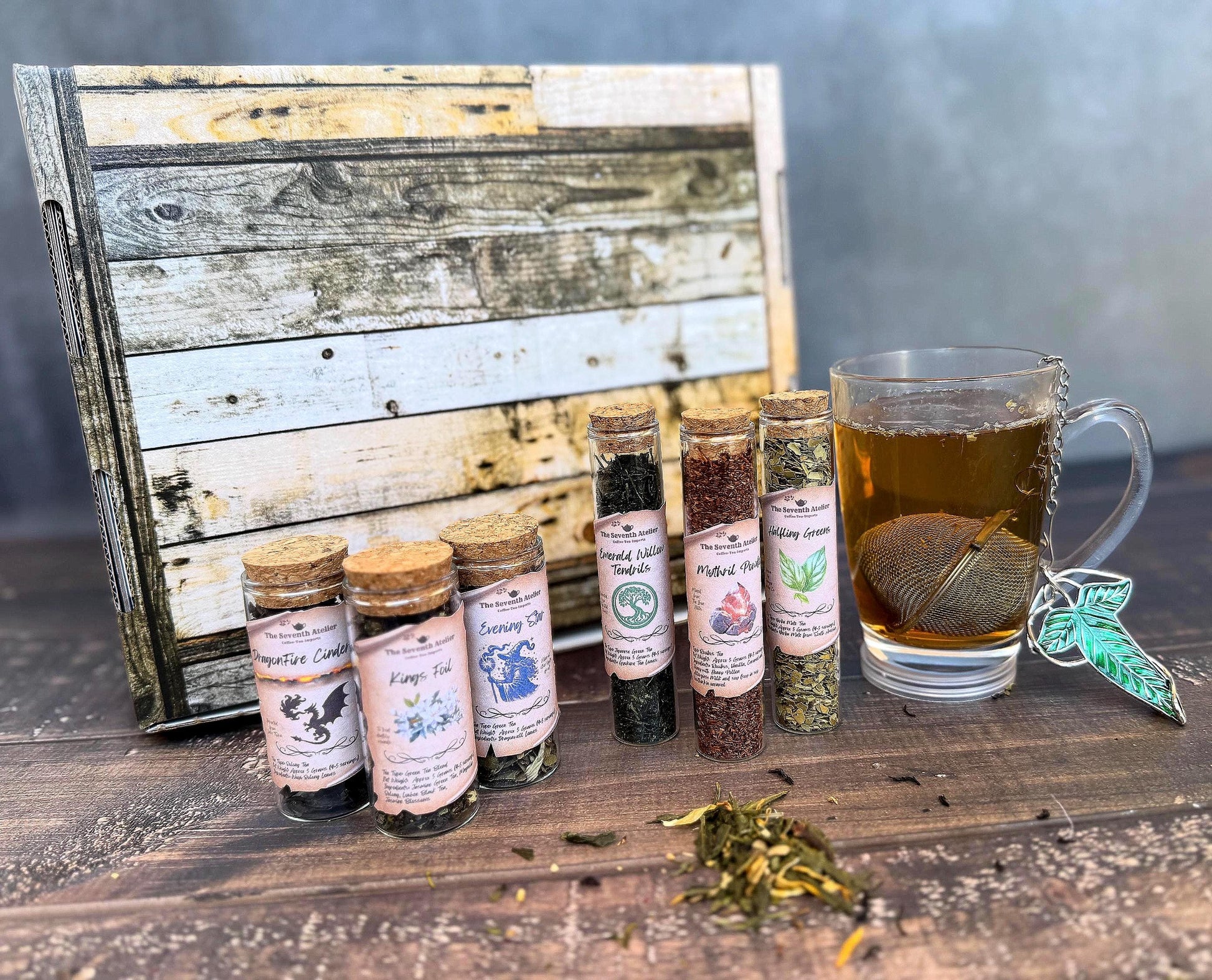 "The Enchanted Realms Gift Crate - Fantasy tea sampler collection featuring 6 premium loose leaf teas in glass jars with cork lids, presented in a wooden gift box"